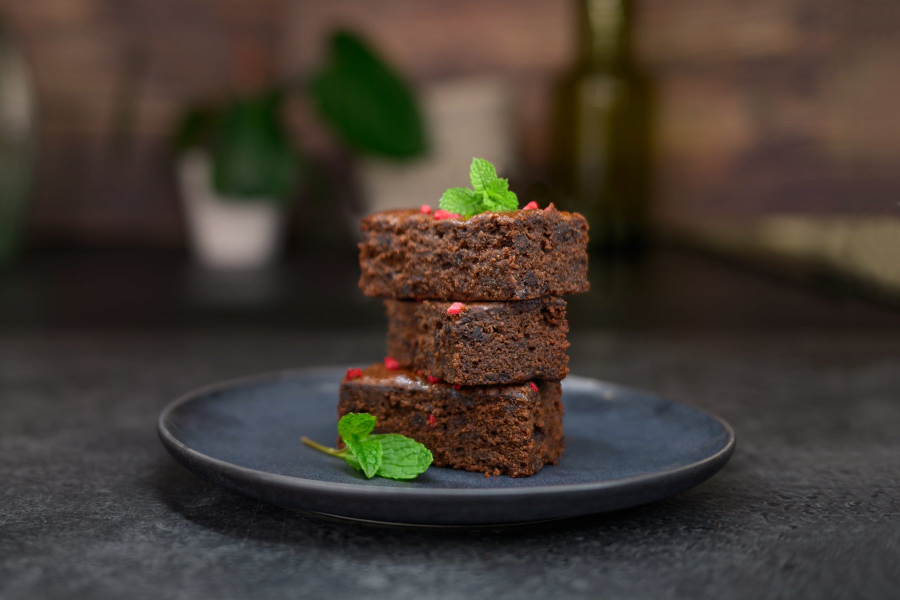 Stack of brownies on a dark plate with a blurred background. Dessert Kitchen Desserts