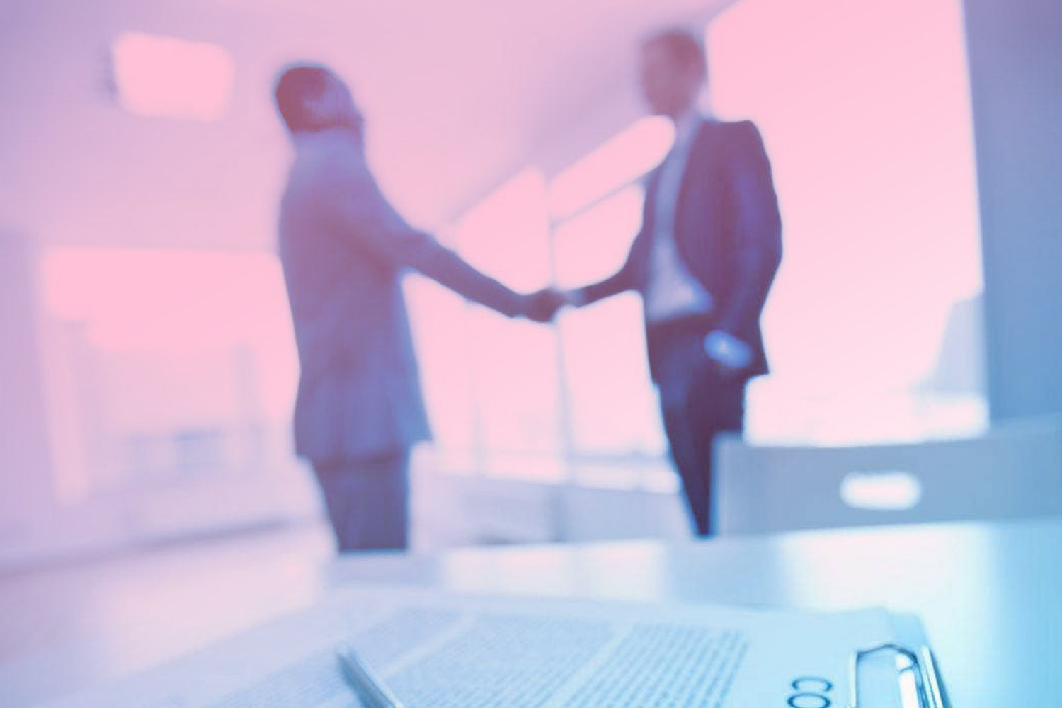 Two business people shaking hands in a blurred office setting. Dessert Kitchen Terms of Trade